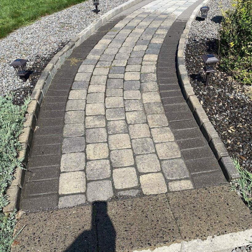 Curved stone walkway with border pavers and landscape lighting in Sandown, NH