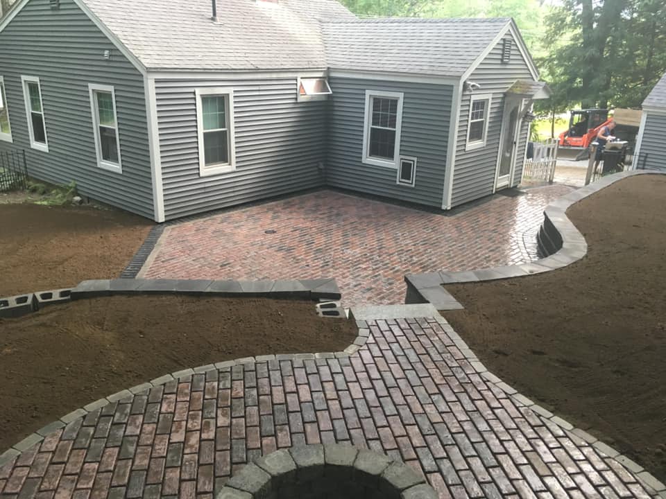 Brick patio and walkway under construction in a backyard in Sandown, NH.